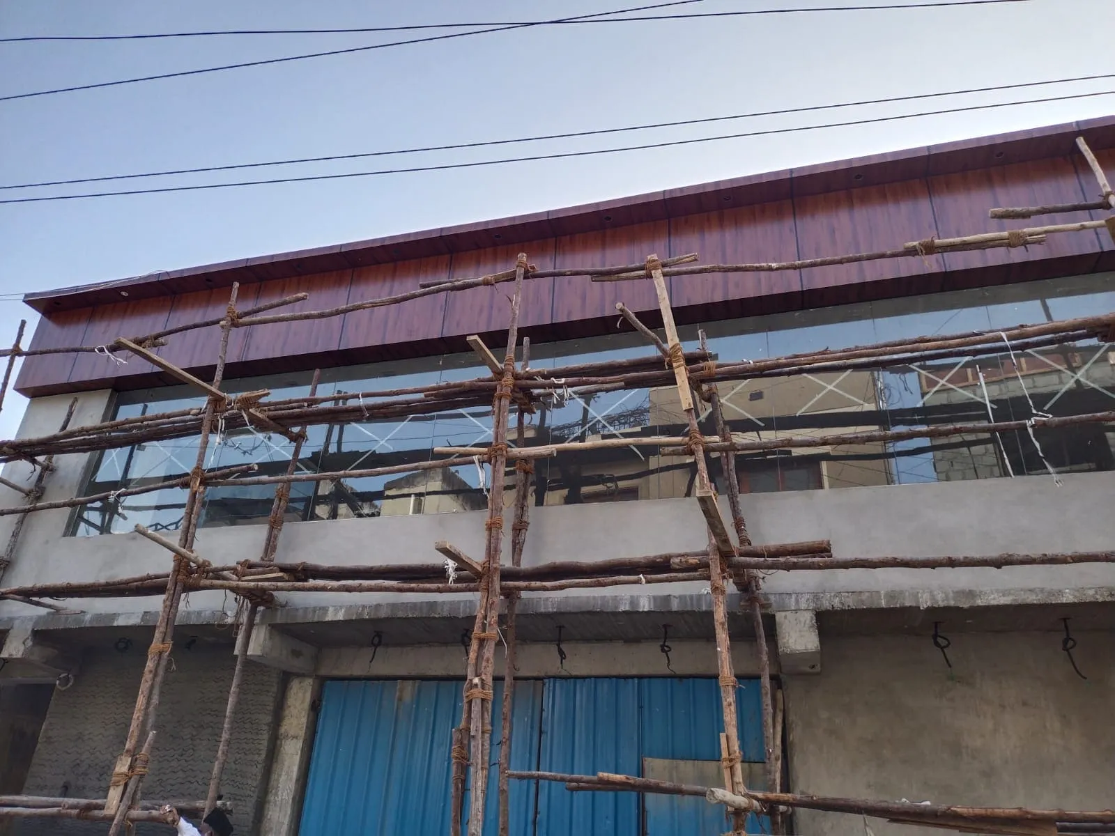 ACP wood finish cladding and glass facade work on a commercial building under construction in Bangalore