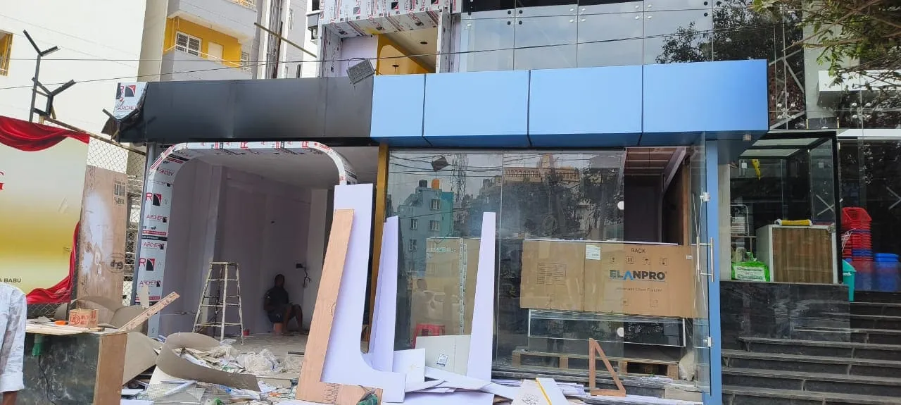 ACP cladding shop front under construction with blue and black panels being installed in Bangalore
