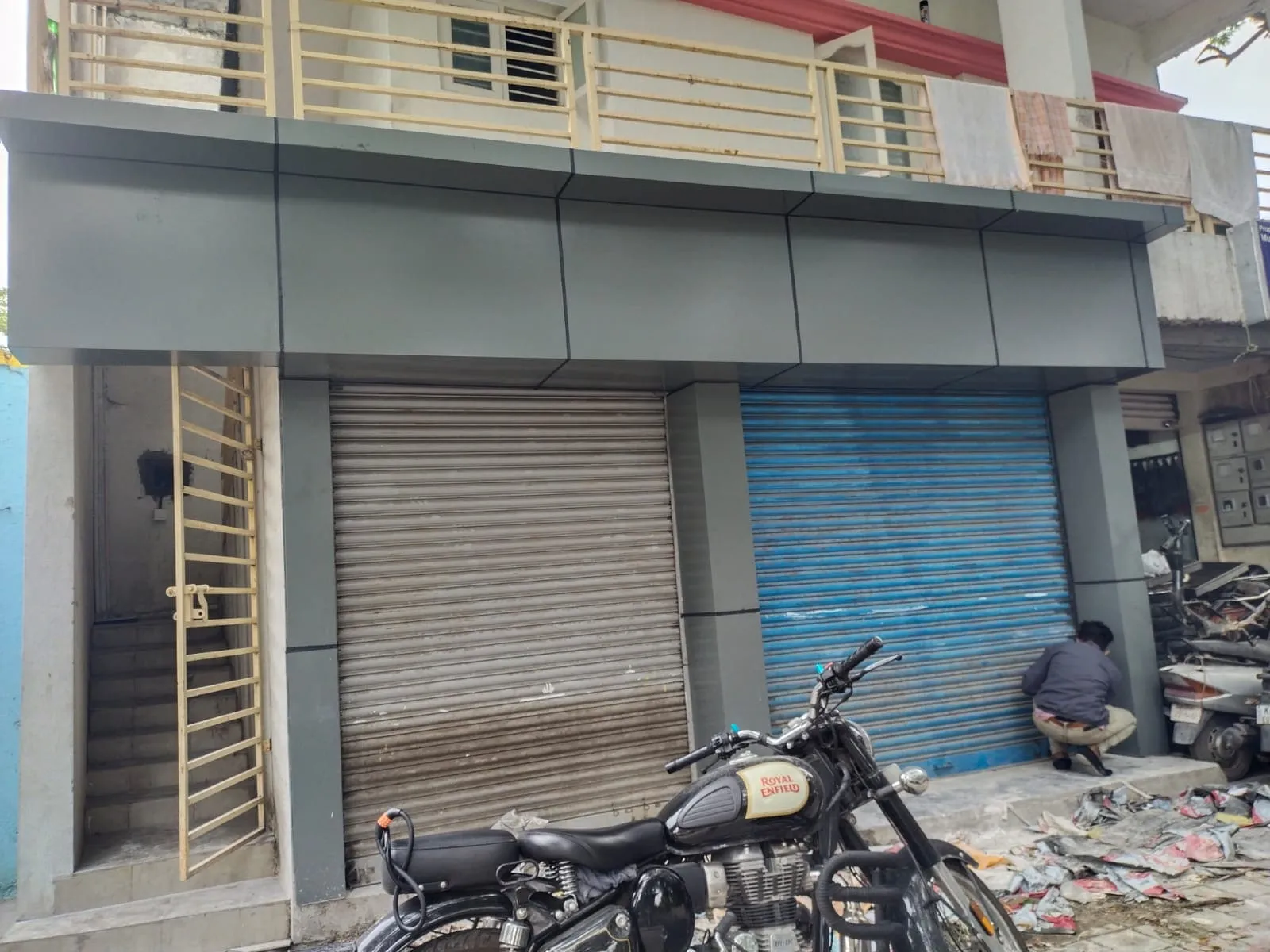 Grey ACP panel cladding installed on a commercial shop front with roller shutters in Bangalore