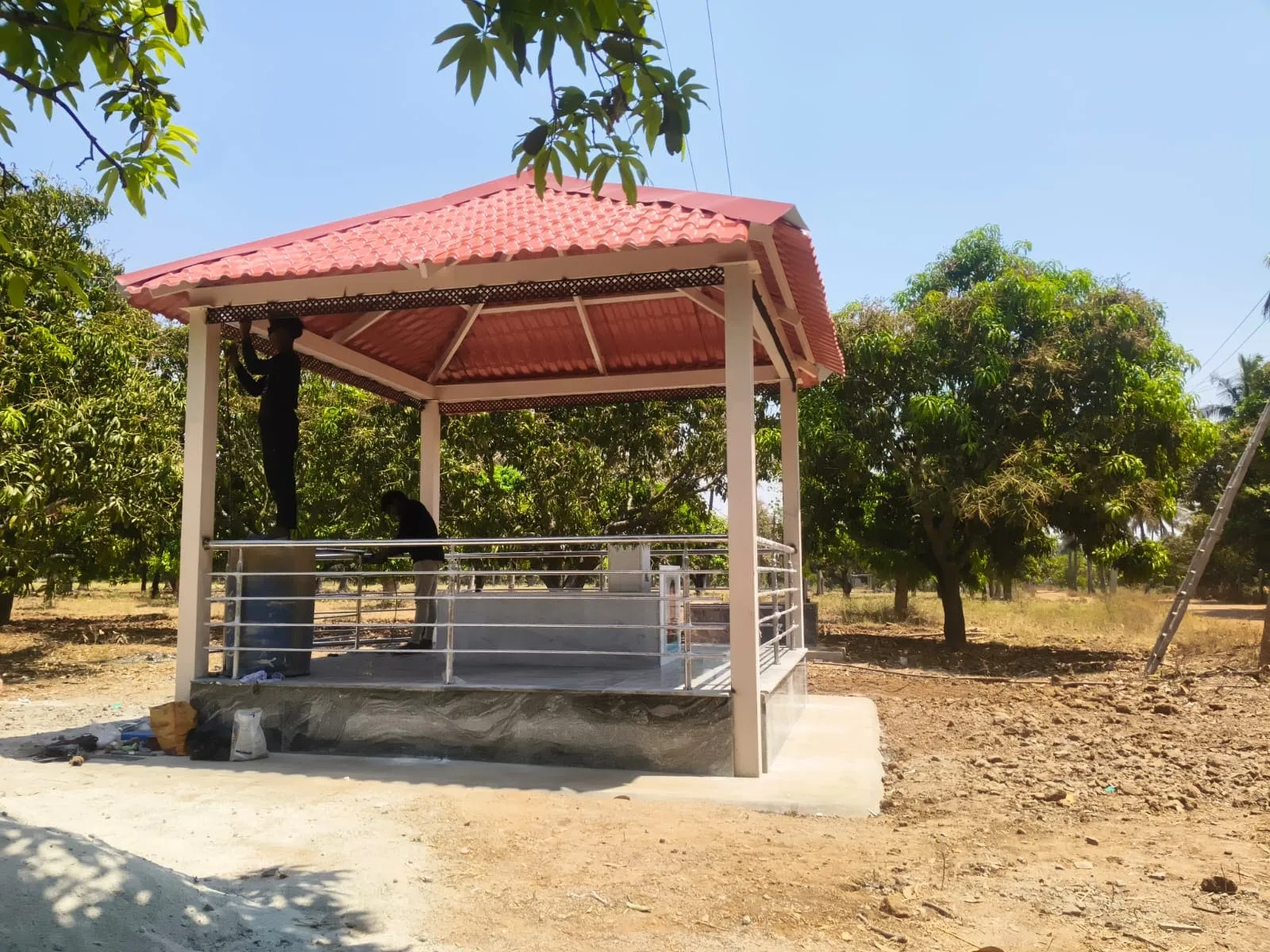 Outdoor gazebo with red tile roof and stainless steel railing constructed in Bangalore
