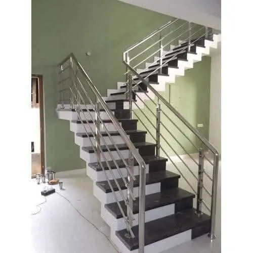 Polished stainless steel vertical bar staircase railing installed on granite steps in a residential building in Bangalore
